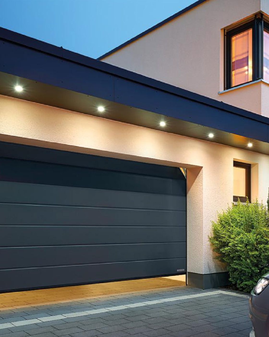 Portone sezionale Blubox antracite illuminato di sera
